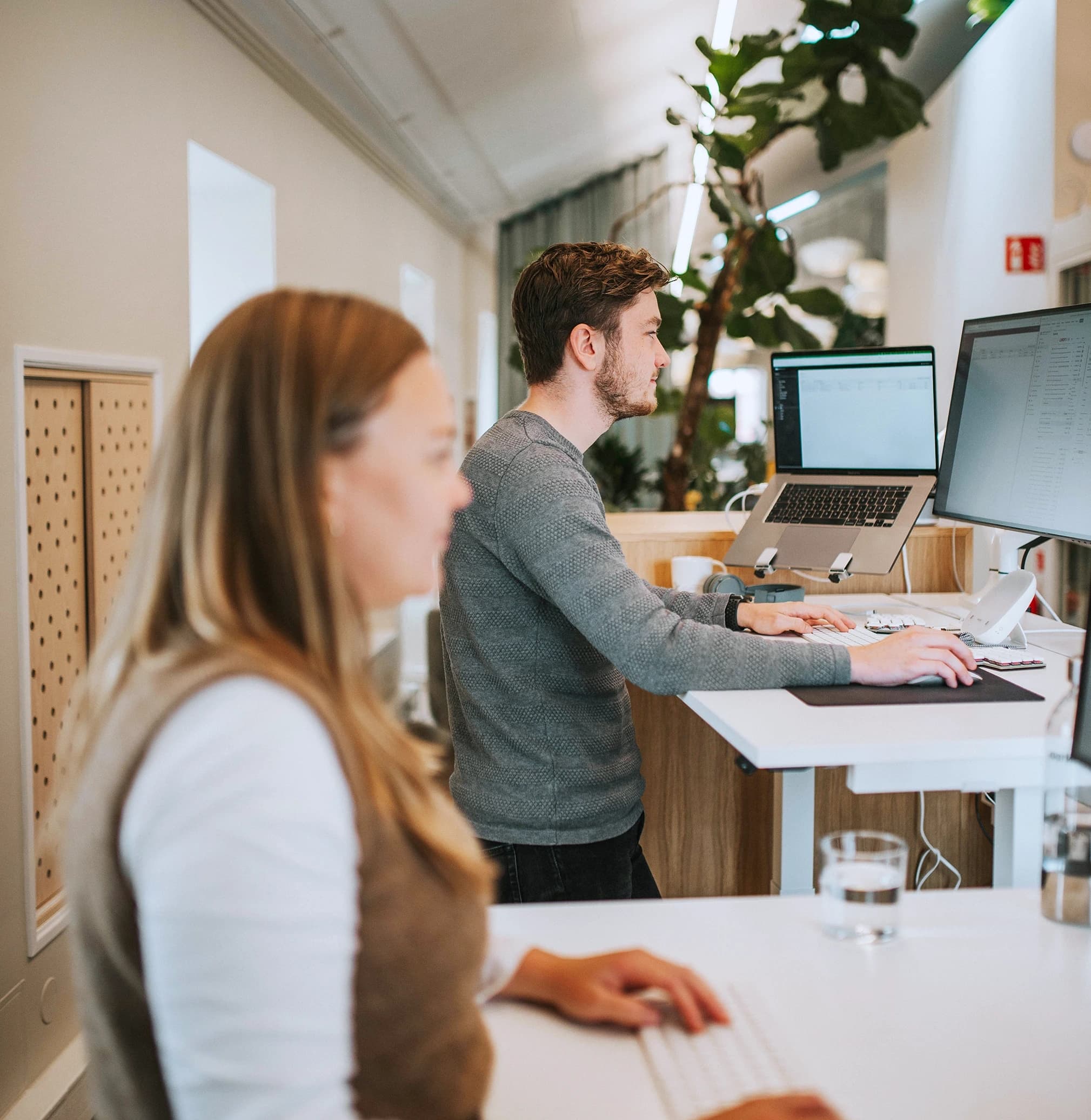 Two developers working at their desks in a modern swedish office