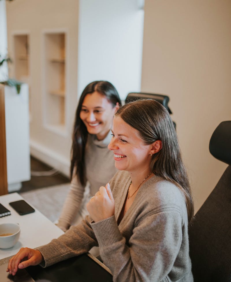 Women laughing by a computer